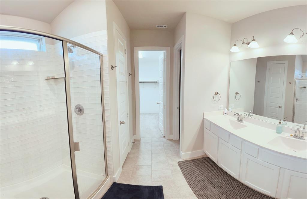 1304 Caprock Drive Forney, TX 75126 - Photo 7 of 15 Full bath featuring a stall shower, double vanity, light tile patterned floors, and a walk in closet
