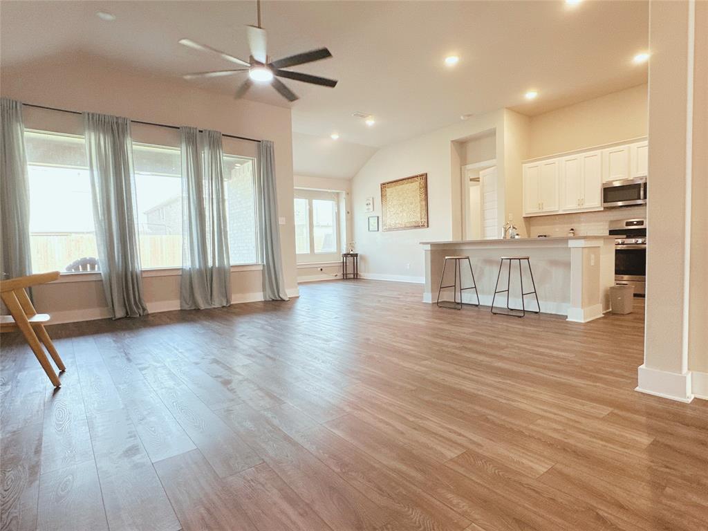 1304 Caprock Drive Forney, TX 75126 - Photo 9 of 15 Unfurnished living room with light wood-style floors, lofted ceiling, recessed lighting, and ceiling fan