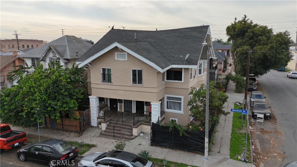 a view of a house with a cars park side of a road