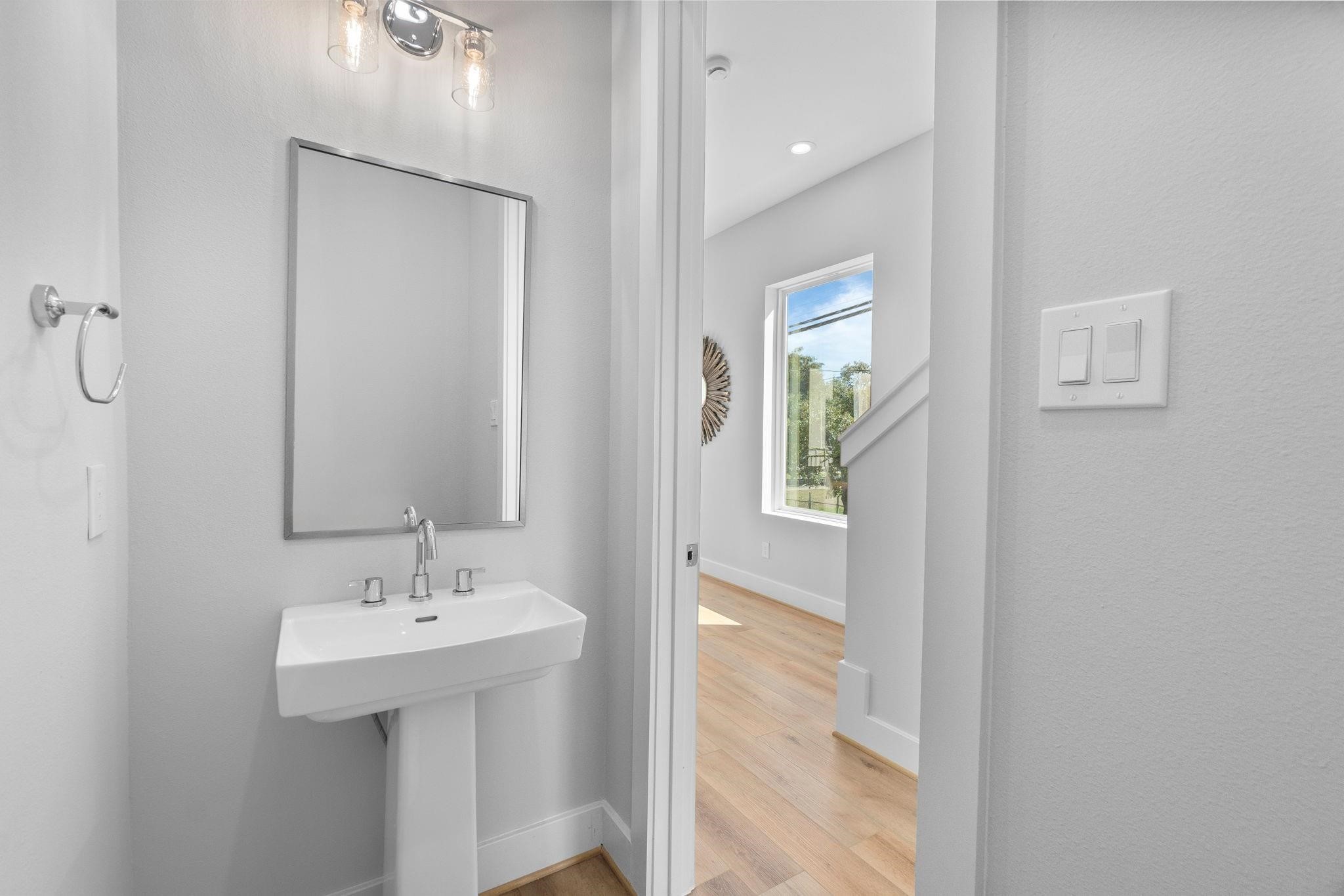 903 Quitman Street, Unit B Houston, TX 77009 - Photo 9 of 24 Stylish powder room featuring a pedestal sink and modern lighting, perfectly positioned for guests on the 2nd floor