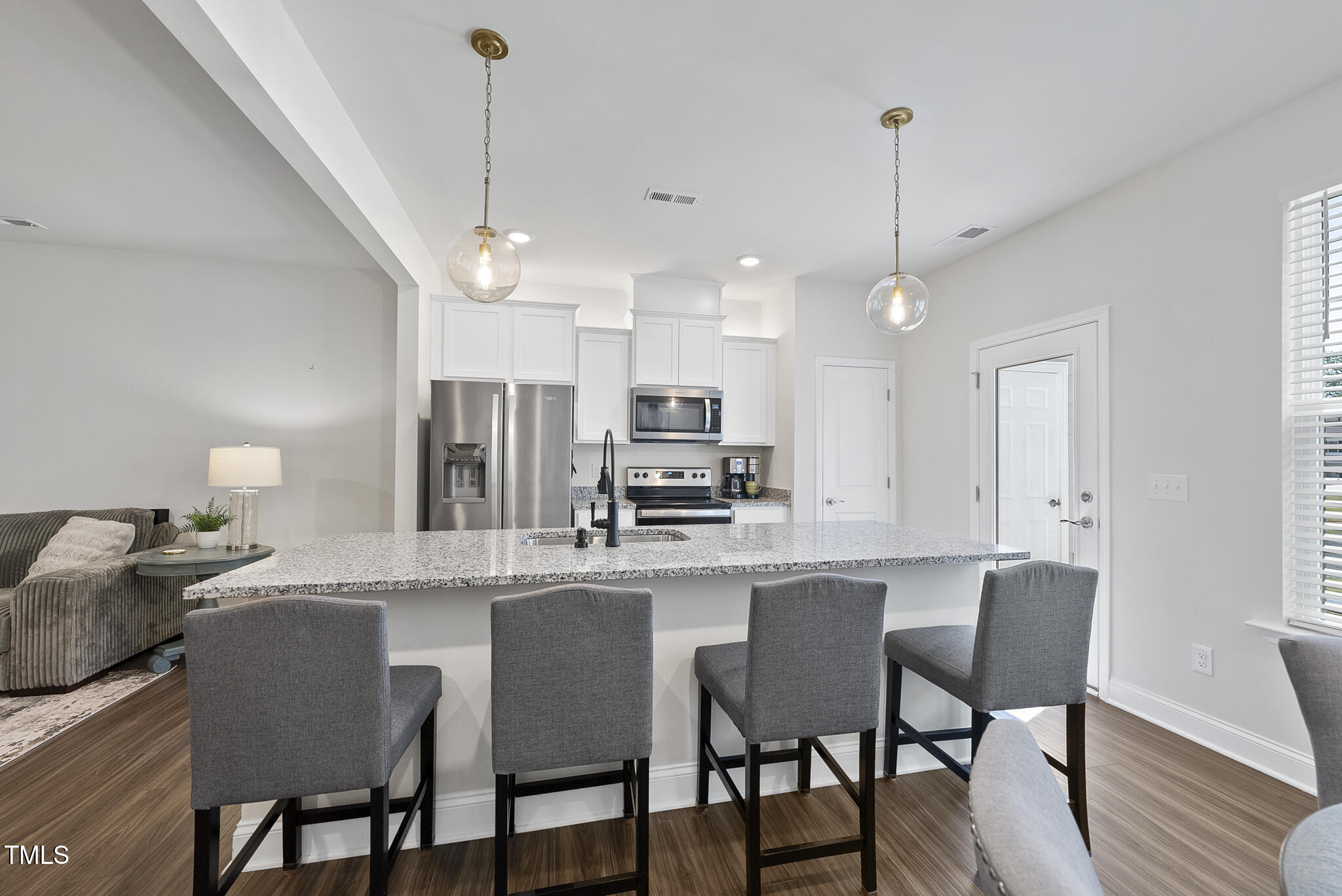 93 Begonia Street Angier, NC 27501 - Photo 10 of 29 a kitchen with stainless steel appliances a dining table chairs stove and wooden floor