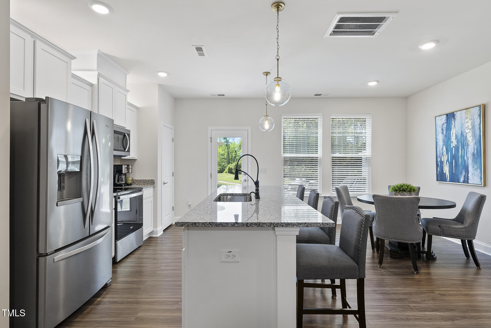 93 Begonia Street Angier, NC 27501 - Photo 13 of 29 a dining room with stainless steel appliances granite countertop a dining table chairs refrigerator and kitchen view