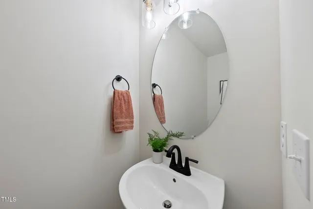 a spacious bedroom with a bed a large window and a chandelier