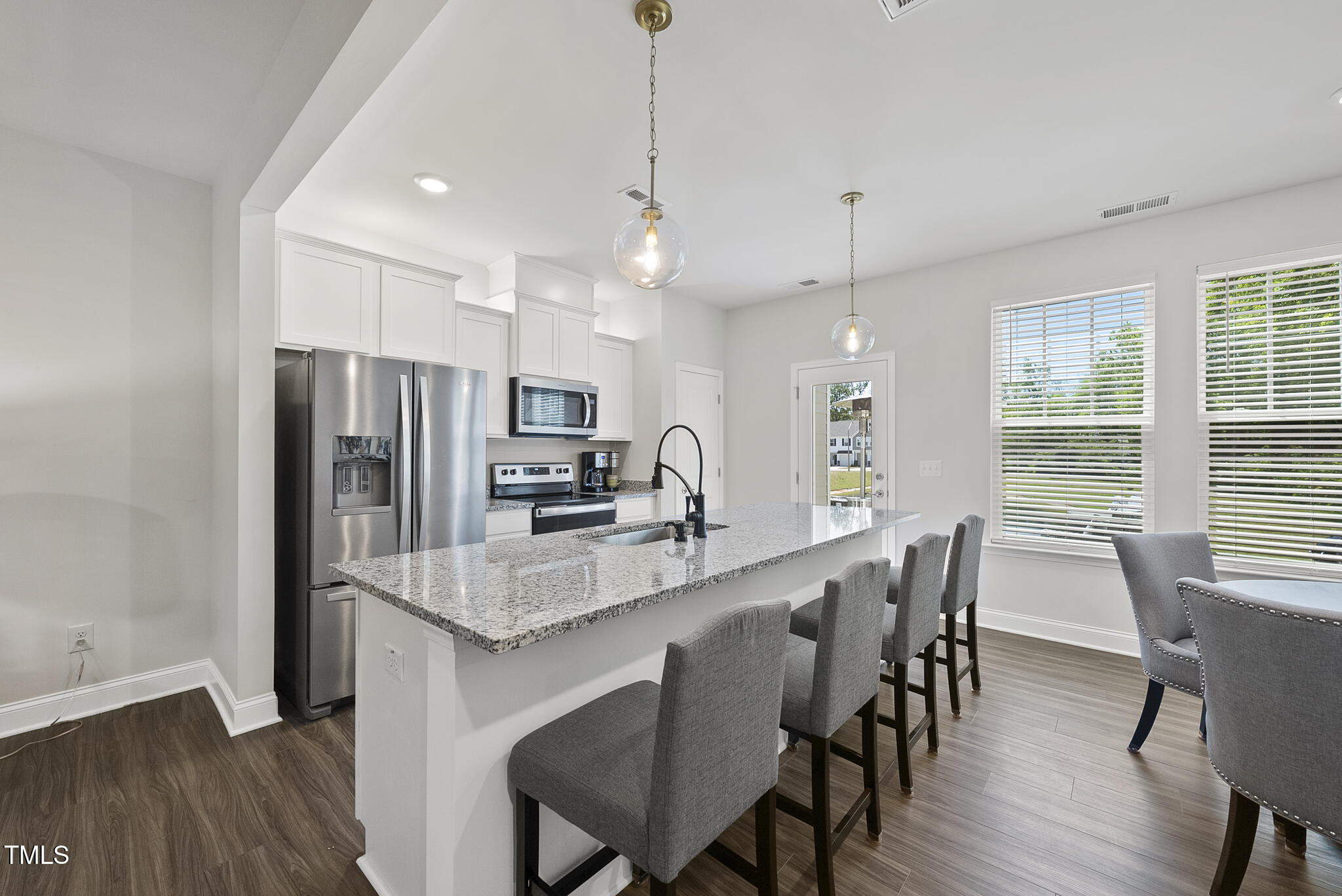 93 Begonia Street Angier, NC 27501 - Photo 3 of 29 a large kitchen with kitchen island a dining table and chairs