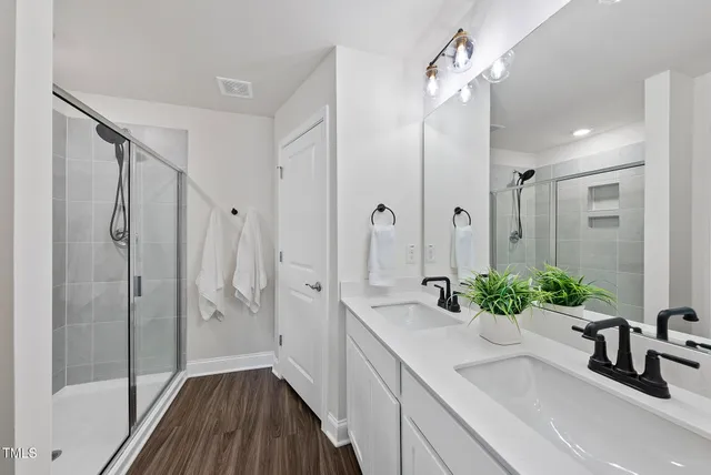 a bathroom with a shower a sink and a large mirror