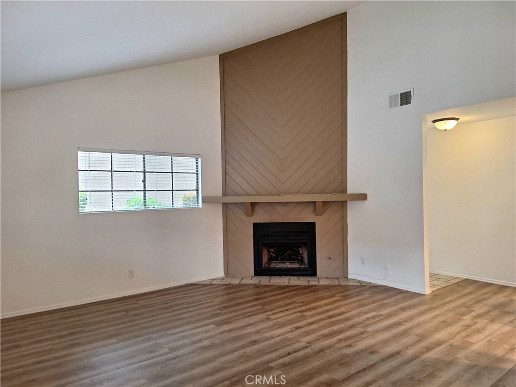 286 Teague Drive San Dimas, CA 91773 - Photo 6 of 16 an empty room with wooden floor a fireplace and window