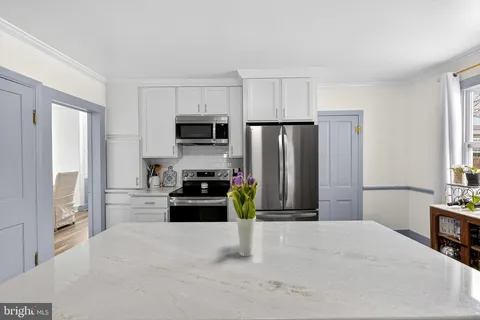 a kitchen with a refrigerator a stove and a microwave
