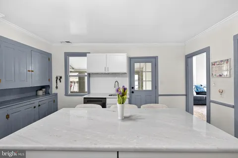 a kitchen with a stove a refrigerator and a white cabinets