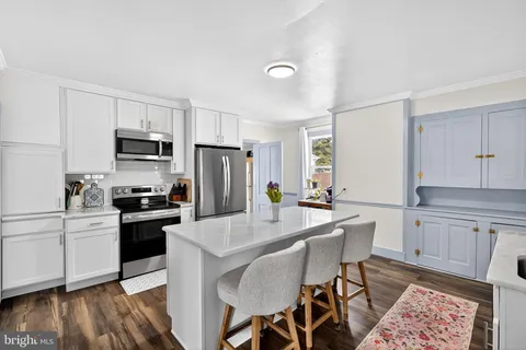 a kitchen with granite countertop a sink appliances and cabinets