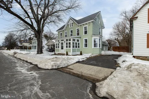 a view of residential houses with snow on the road