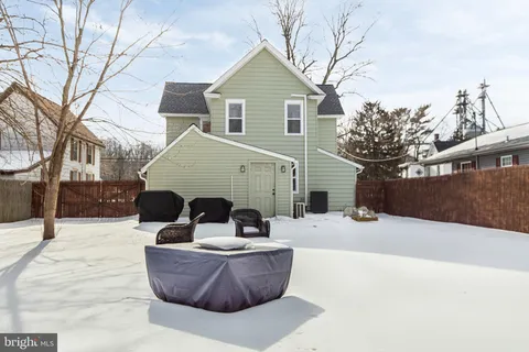 a front view of a house with a yard covered in snow