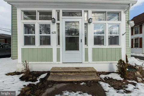 a front view of a house with a lots of windows and plants