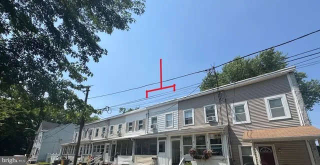 a front view of a house with a tree