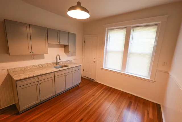 a kitchen with a sink cabinets and wooden floor
