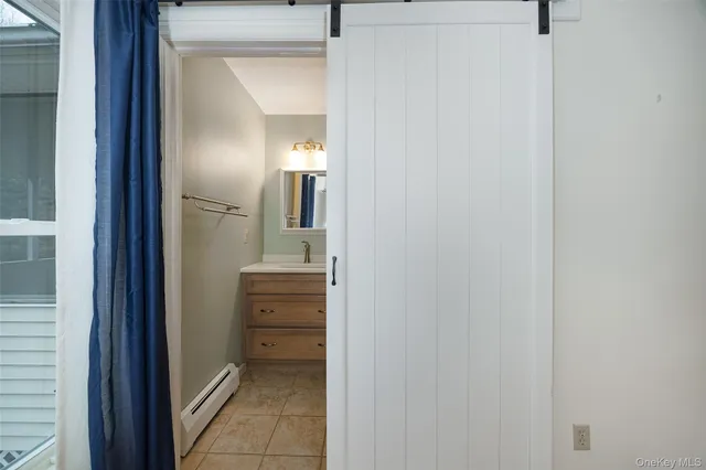 a bathroom with a sink a toilet a mirror and shower