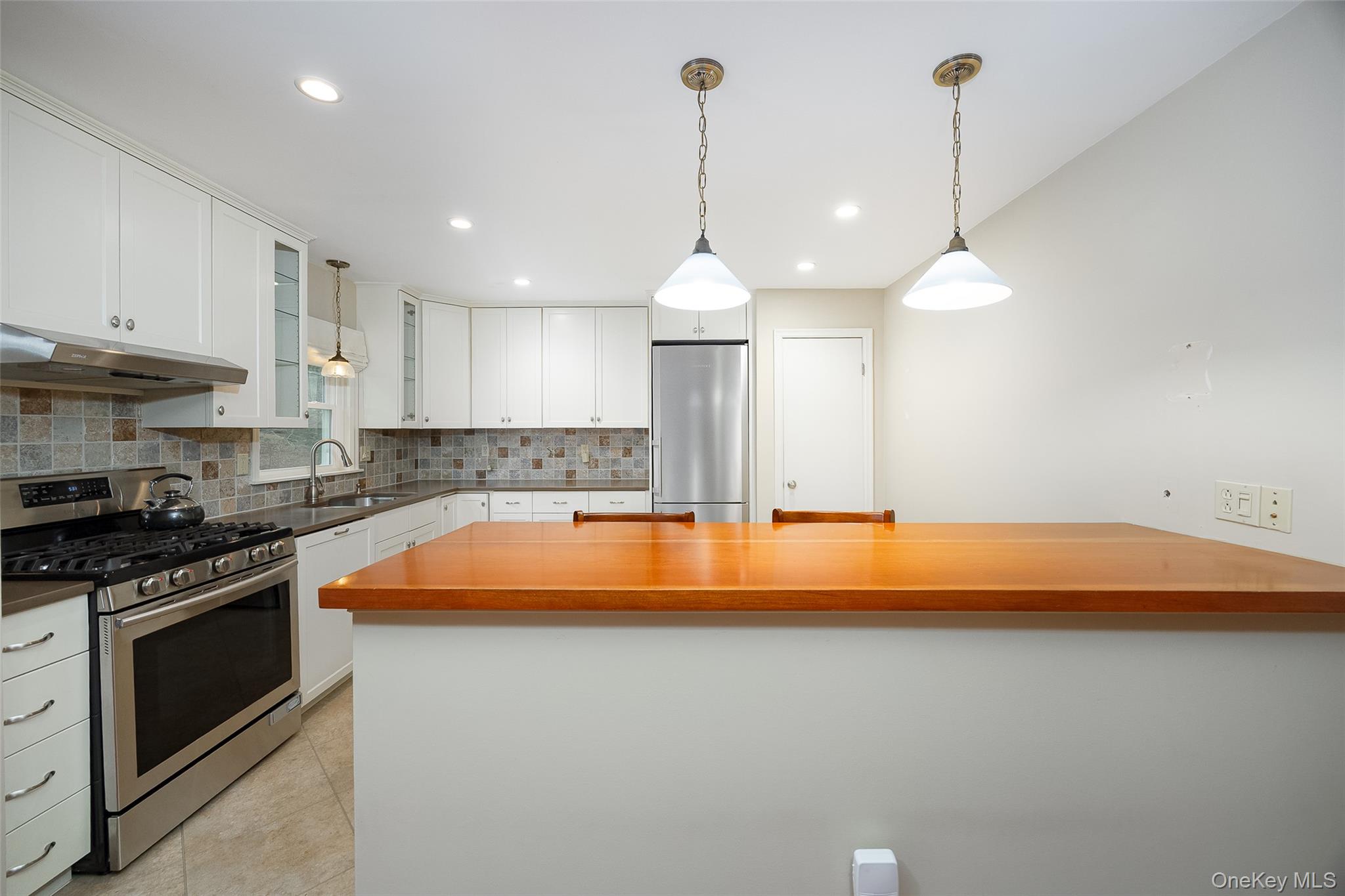 26 St Paul Road Red Hook, NY 12571 - Photo 7 of 35 a kitchen with kitchen island a stove a counter a sink and a wooden floor