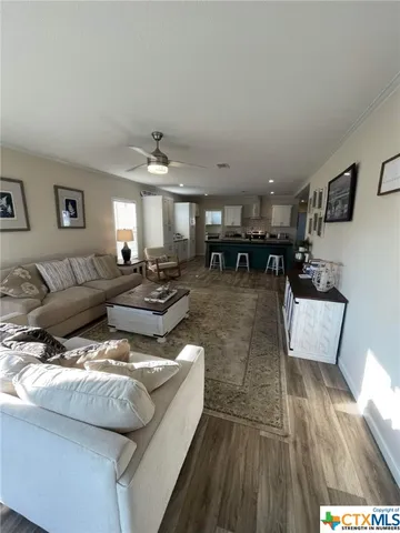 a living room with lots of furniture and view of kitchen