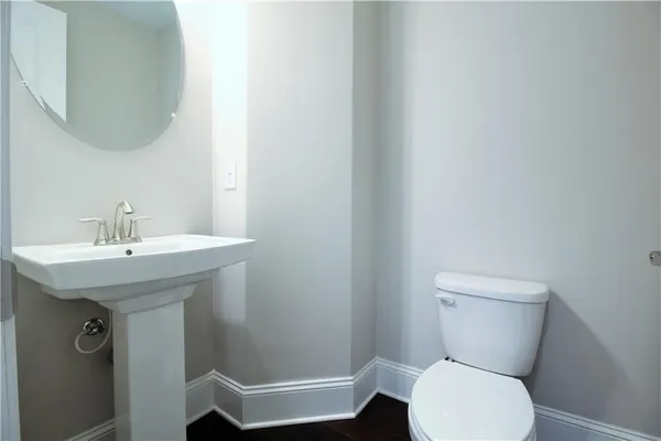 a bathroom with a toilet a sink and mirror