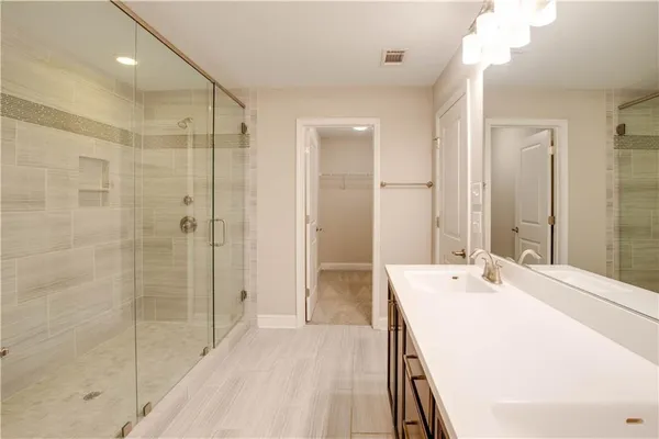 a spacious bathroom with a shower sink and mirror