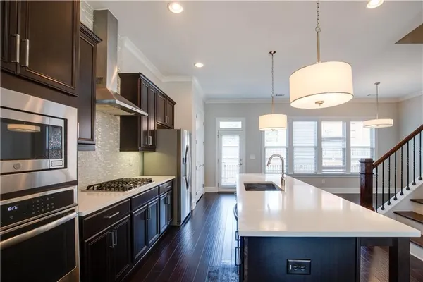 a kitchen with stainless steel appliances granite countertop a stove a sink and a microwave