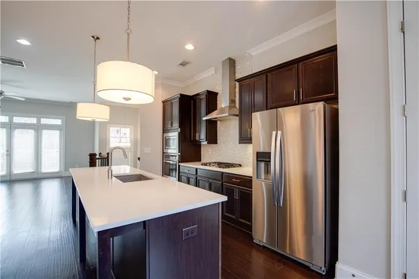 a kitchen with stainless steel appliances a refrigerator a stove a sink and a microwave