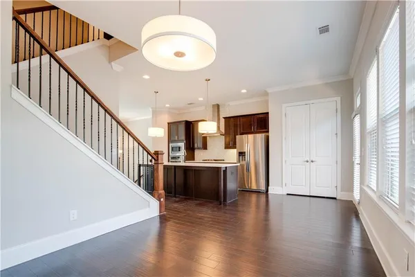 a view of living room with stainless steel appliances wooden floor and windows