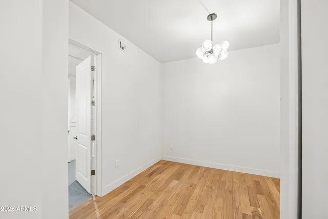 a view of an empty room with chandelier fan