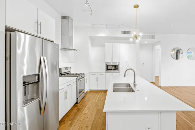a kitchen with stainless steel appliances a refrigerator sink and cabinets