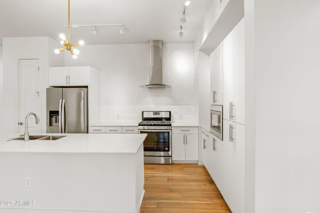 a kitchen with stainless steel appliances a stove a sink and a refrigerator