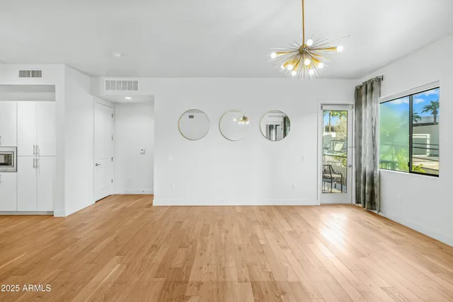 a view of empty room with window and wooden floor