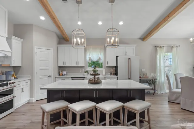 a large kitchen with kitchen island a dining table and chairs