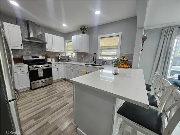 a kitchen with a sink a stove a refrigerator and cabinets