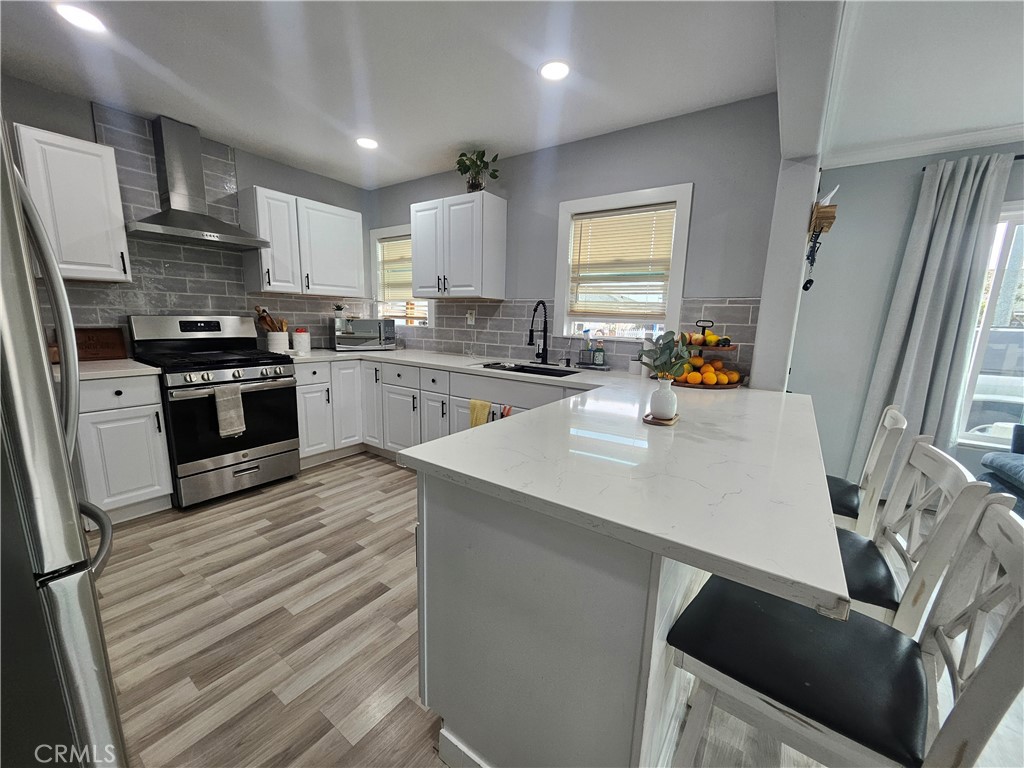 629 West Plum Street Compton, CA 90222 - Photo 5 of 15 a kitchen with a sink a stove a refrigerator and cabinets