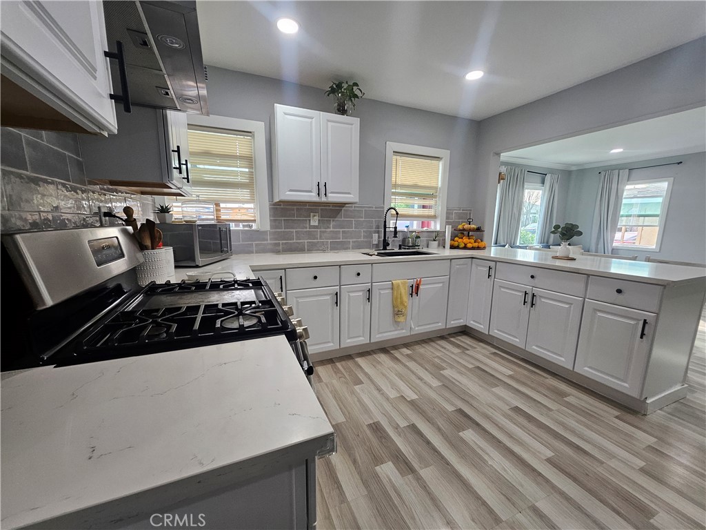 629 West Plum Street Compton, CA 90222 - Photo 6 of 15 a kitchen with stainless steel appliances a stove sink and cabinets