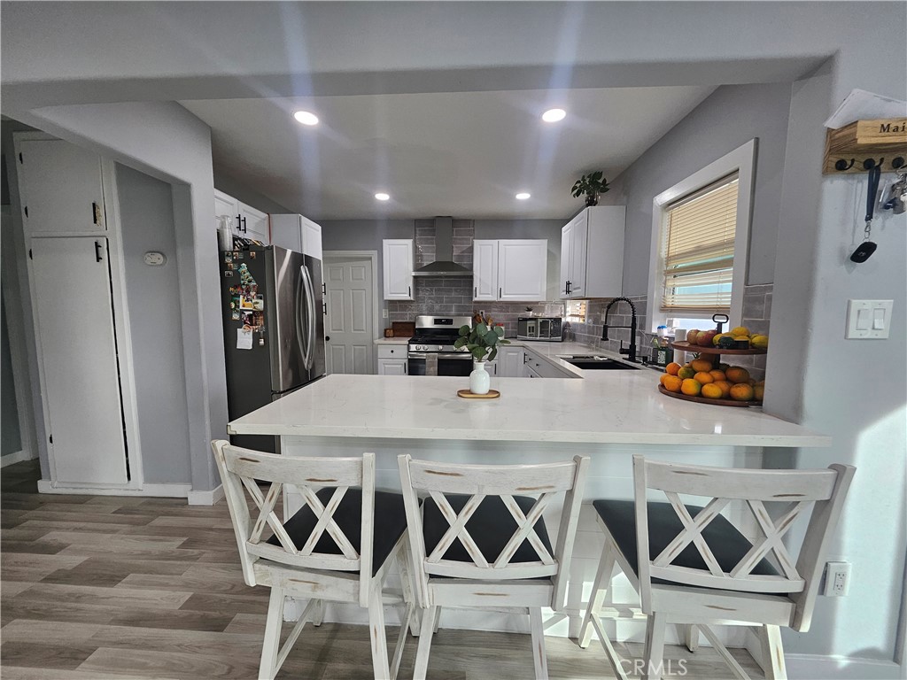 629 West Plum Street Compton, CA 90222 - Photo 7 of 15 a kitchen with stainless steel appliances a dining table chairs refrigerator and sink