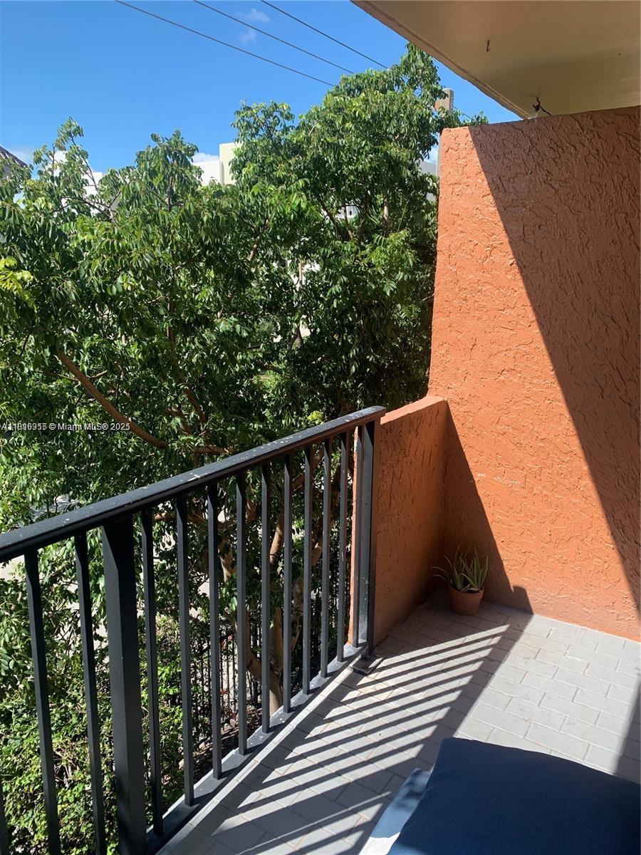 677 Southwest 9th Avenue, Unit 303 Miami, FL 33130 - Photo 29 of 34 a balcony with wooden floor and fence