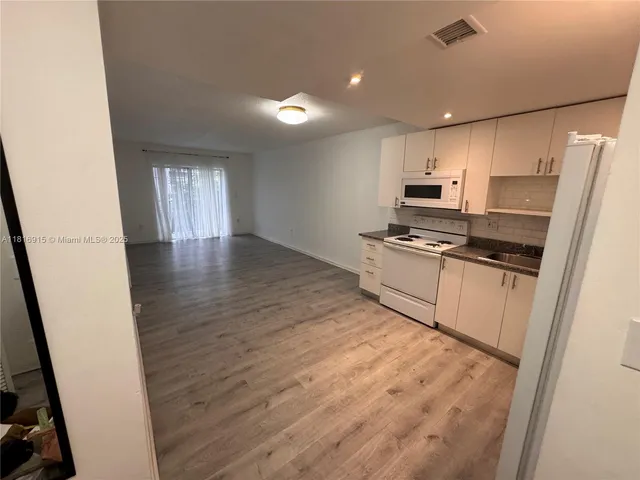a kitchen with stainless steel appliances a refrigerator and a stove top oven