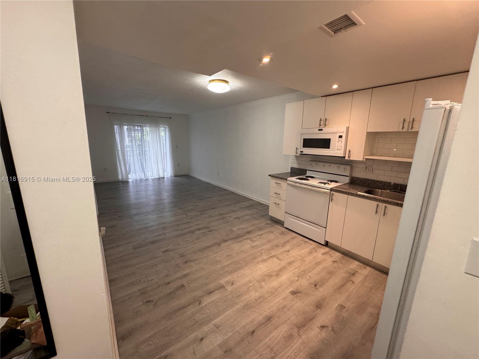 677 Southwest 9th Avenue, Unit 303 Miami, FL 33130 - Photo 3 of 34 a kitchen with stainless steel appliances a refrigerator and a stove top oven