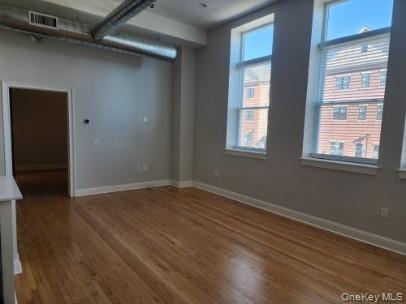 17-anya Court, Unit 301 Poughkeepsie, NY 12603 - Photo 2 of 9 an empty room with wooden floor and windows