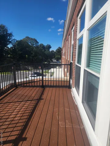 a view of balcony with wooden floor and fence