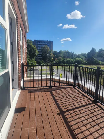 a view of balcony with wooden floor and fence
