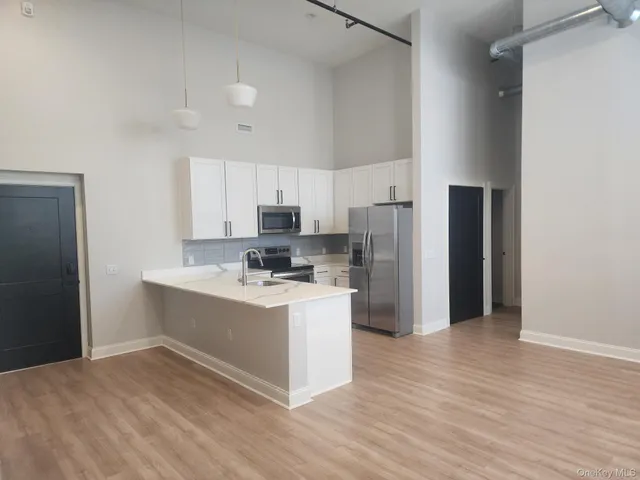 a kitchen with stainless steel appliances a refrigerator and a stove top oven