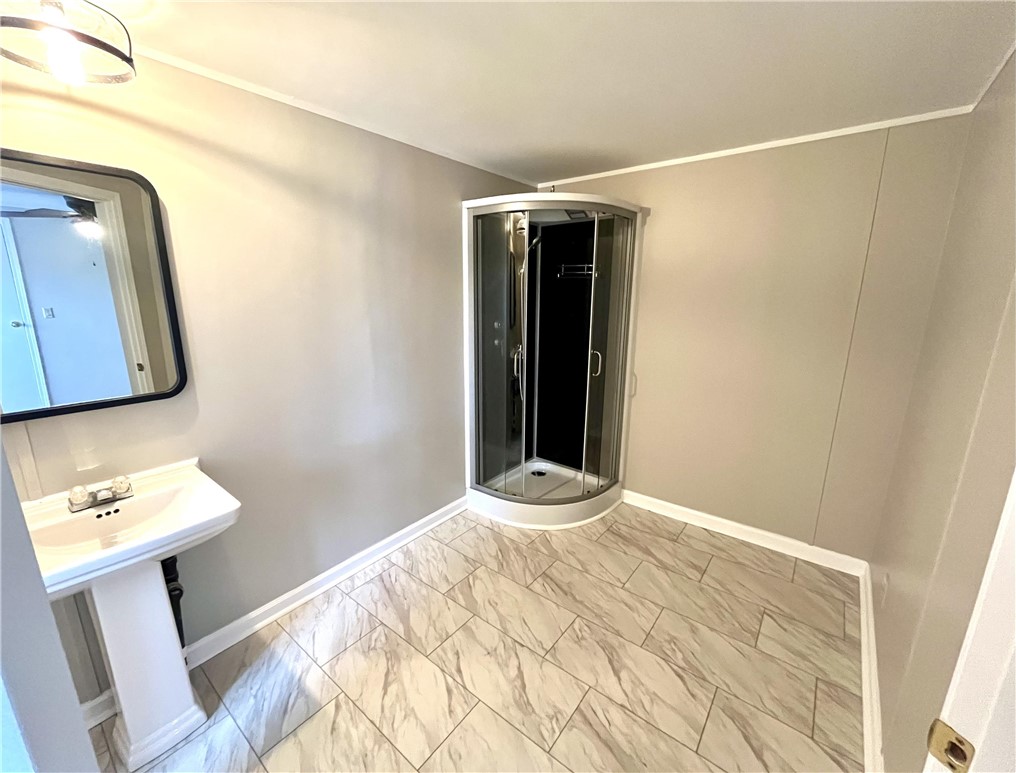 212 Whitewater Lake Road Tamassee, SC 29686 - Photo 2 of 9 A well-appointed bathroom features a pedestal sink and a corner shower enclosure.