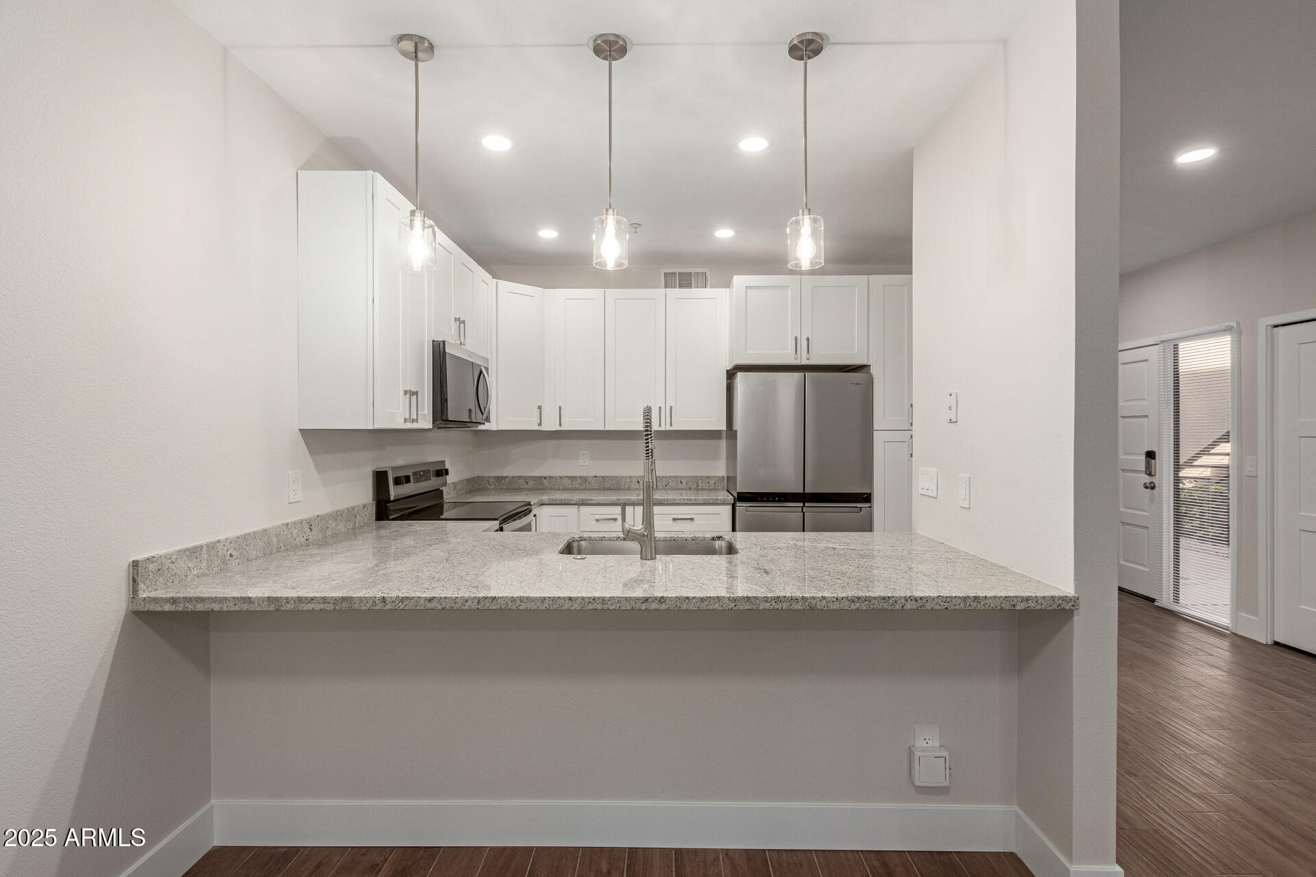 7700 East Gainey Ranch Road, Unit 102 Scottsdale, AZ 85258 - Photo 10 of 40 a large kitchen with granite countertop a sink a counter top space stainless steel appliances and cabinets