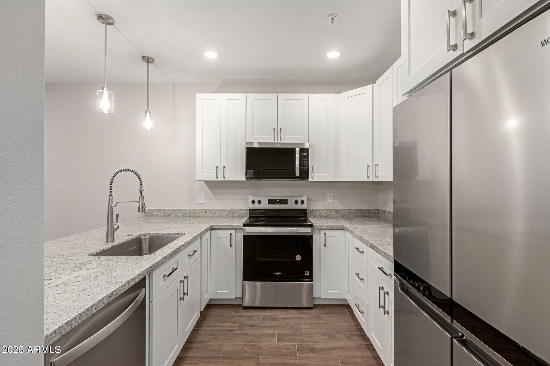7700 East Gainey Ranch Road, Unit 102 Scottsdale, AZ 85258 - Photo 11 of 40 a kitchen with white cabinets and stainless steel appliances
