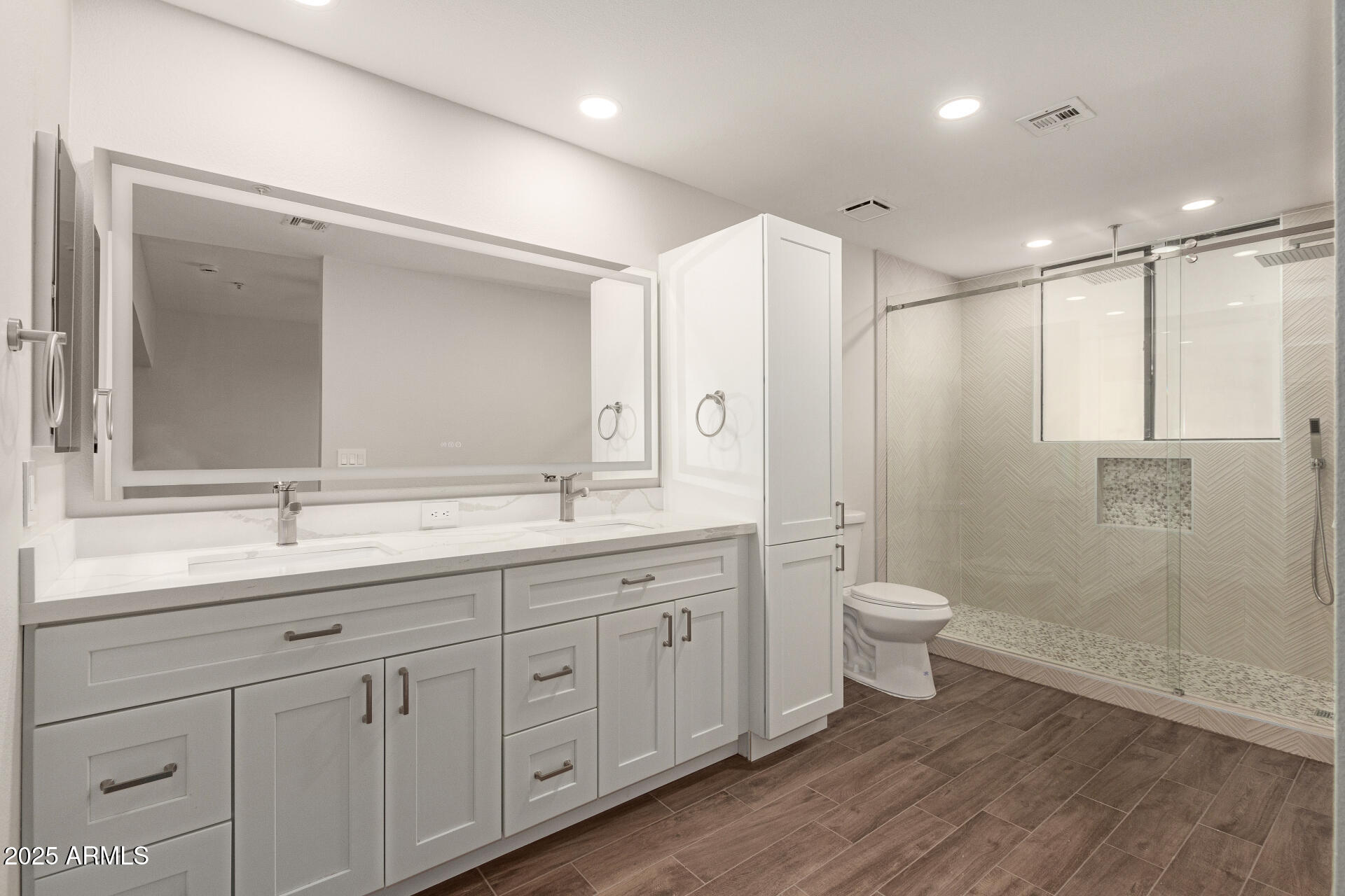 7700 East Gainey Ranch Road, Unit 102 Scottsdale, AZ 85258 - Photo 16 of 40 a bathroom with a double vanity sink a toilet and a mirror