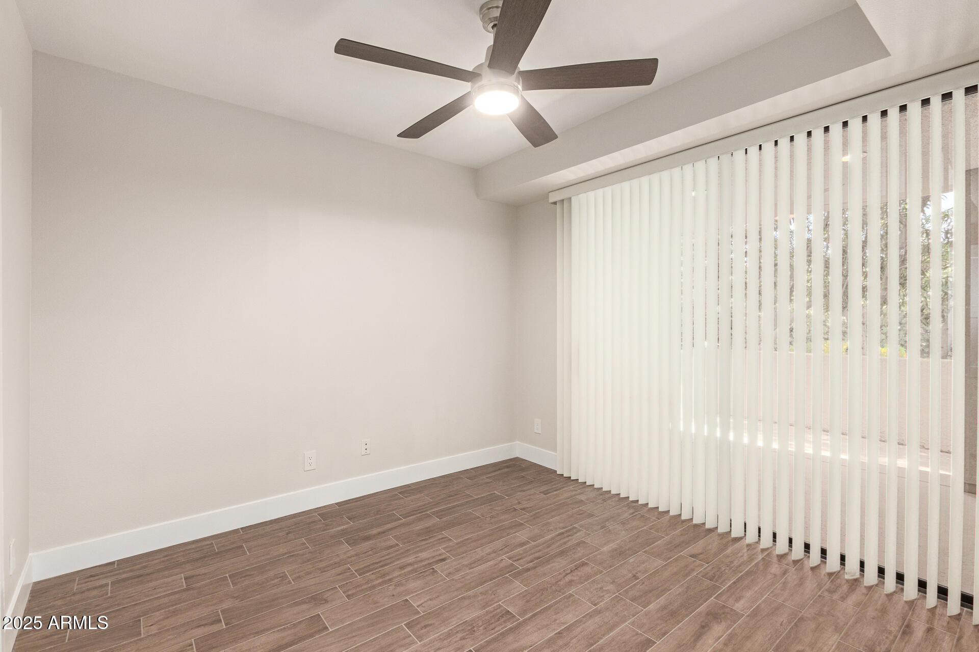7700 East Gainey Ranch Road, Unit 102 Scottsdale, AZ 85258 - Photo 24 of 40 an empty room with wooden floor fan and windows
