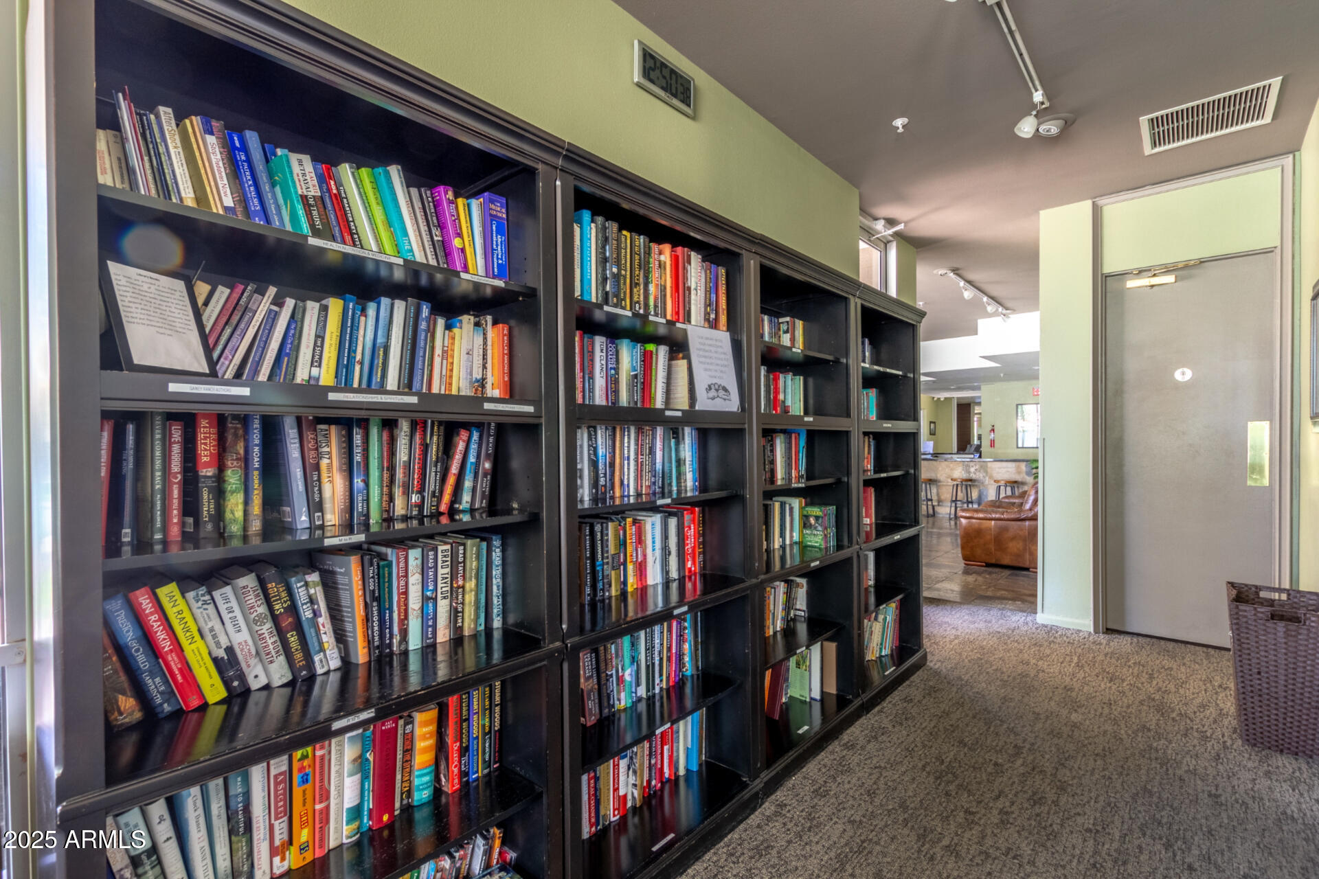 7700 East Gainey Ranch Road, Unit 102 Scottsdale, AZ 85258 - Photo 37 of 40 a living room with a book shelf and a book shelf