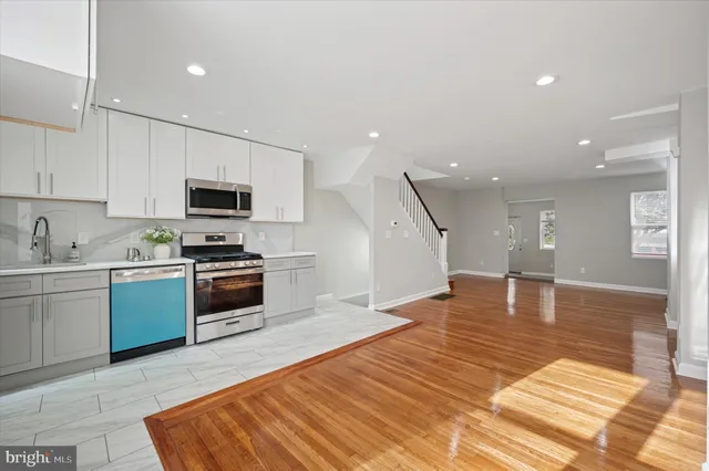 a kitchen with stainless steel appliances granite countertop a refrigerator stove top oven and sink