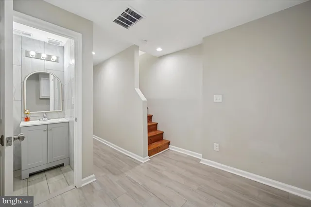 a view of a hallway with entryway wooden floor and cabinet